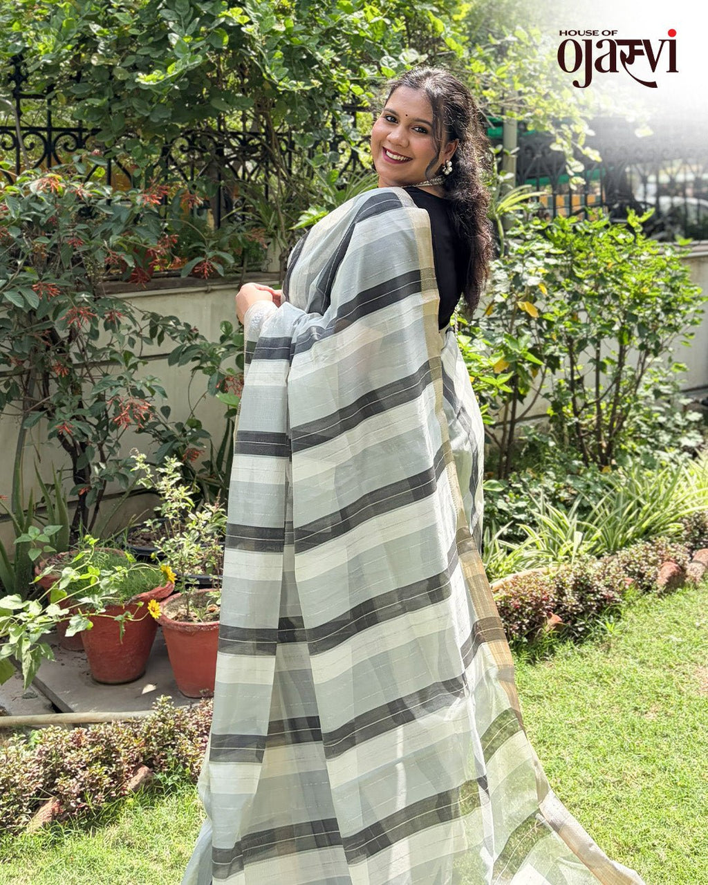 Lifestyle view of a model styling the black and white checked handwoven Maheshwari saree.