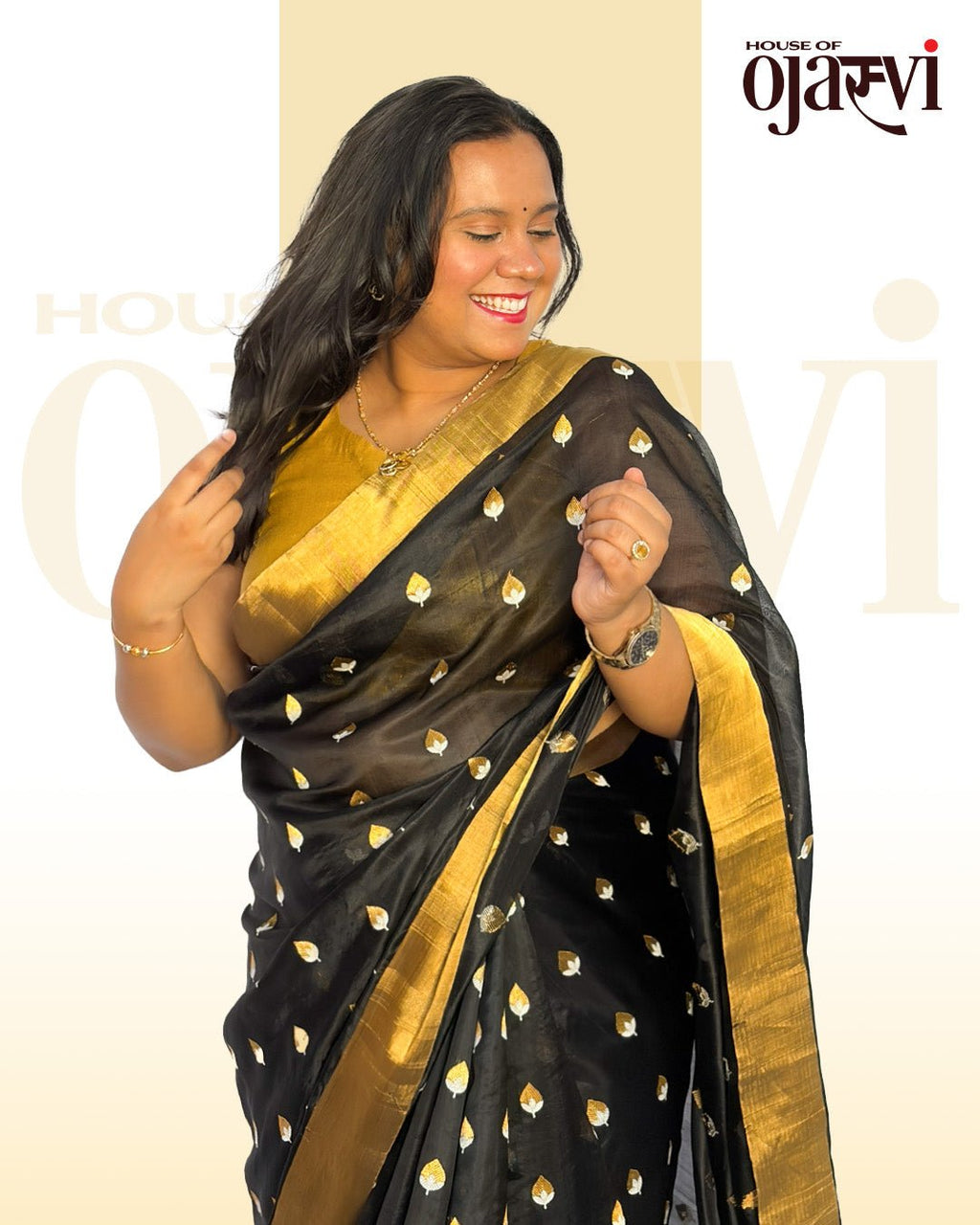 Close-up detail of the golden blouse, gold necklace, and fine gold and silver zari leaf work on the black saree.