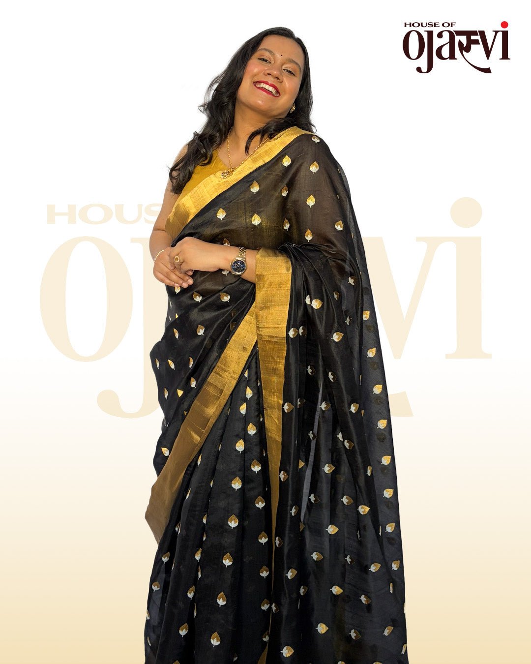 Smiling model presenting the premium drape of House of Ojasvi's black Chanderi zari saree against a warm cream background.