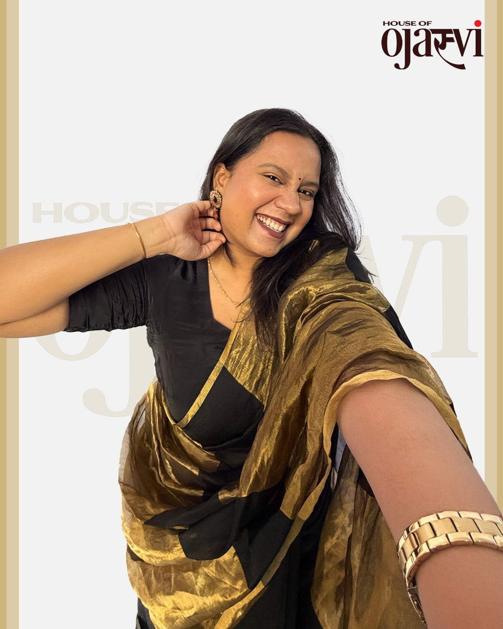 Joyful model laughing, showing off the rich texture and golden watch pairing with the black and gold Chanderi saree.