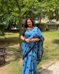 Full-length view of the powder blue polka dot cotton handwoven saree showing neat pleats and a crisp black border