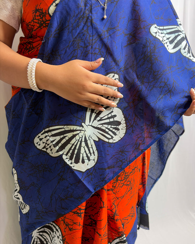Close-up detail of the white butterfly motif and black batik crackle print on the blue and orange cotton saree by House of Ojasvi