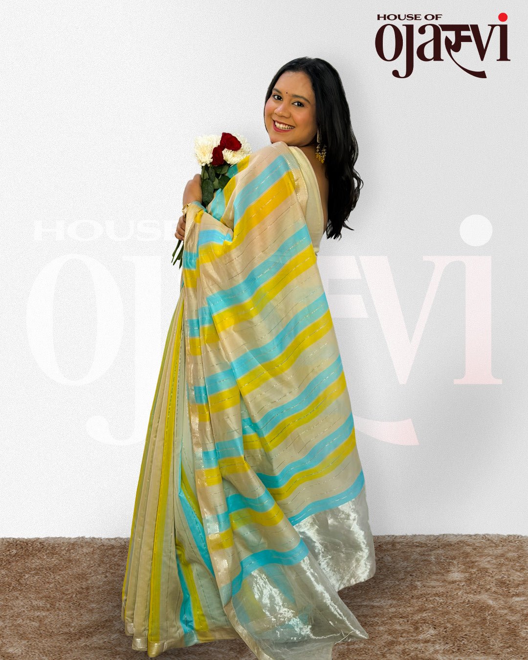 Lifestyle view of a model wearing the blue and yellow striped Maheshwari handwoven saree with a rich zari border.