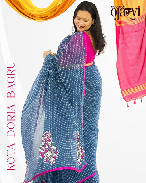Model wearing blue checked handwoven Kota Doria saree with vibrant pink border and matching pink blouse by House of Ojasvi.