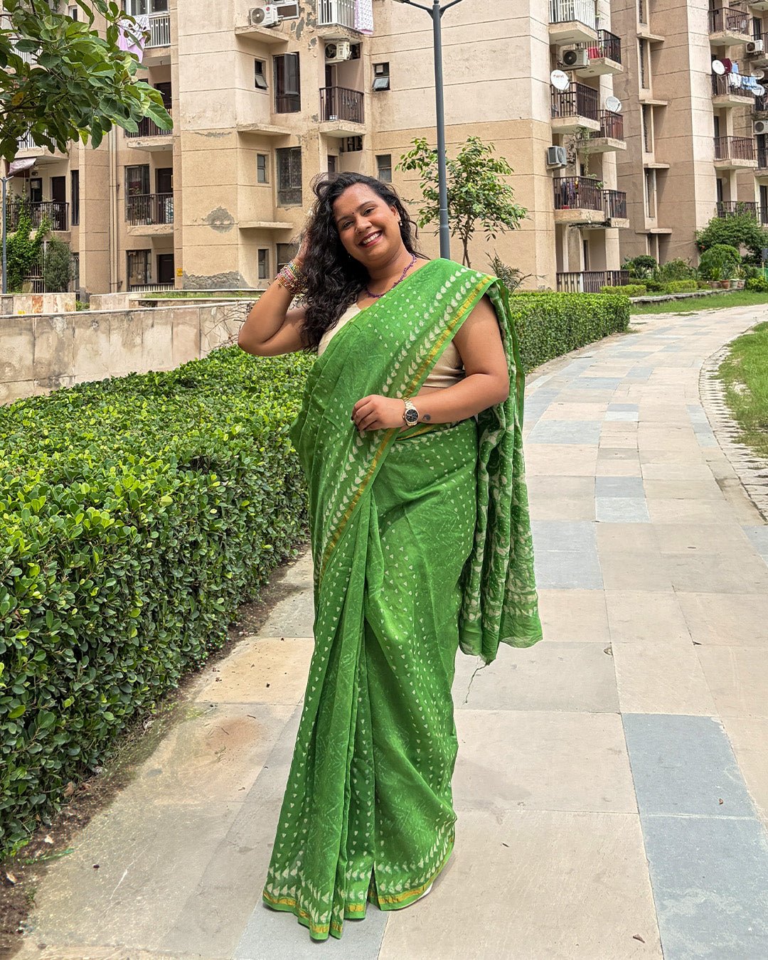 Joyful model posing in the lightweight green Chanderi saree, showcasing the breezy drape and elegant fall.