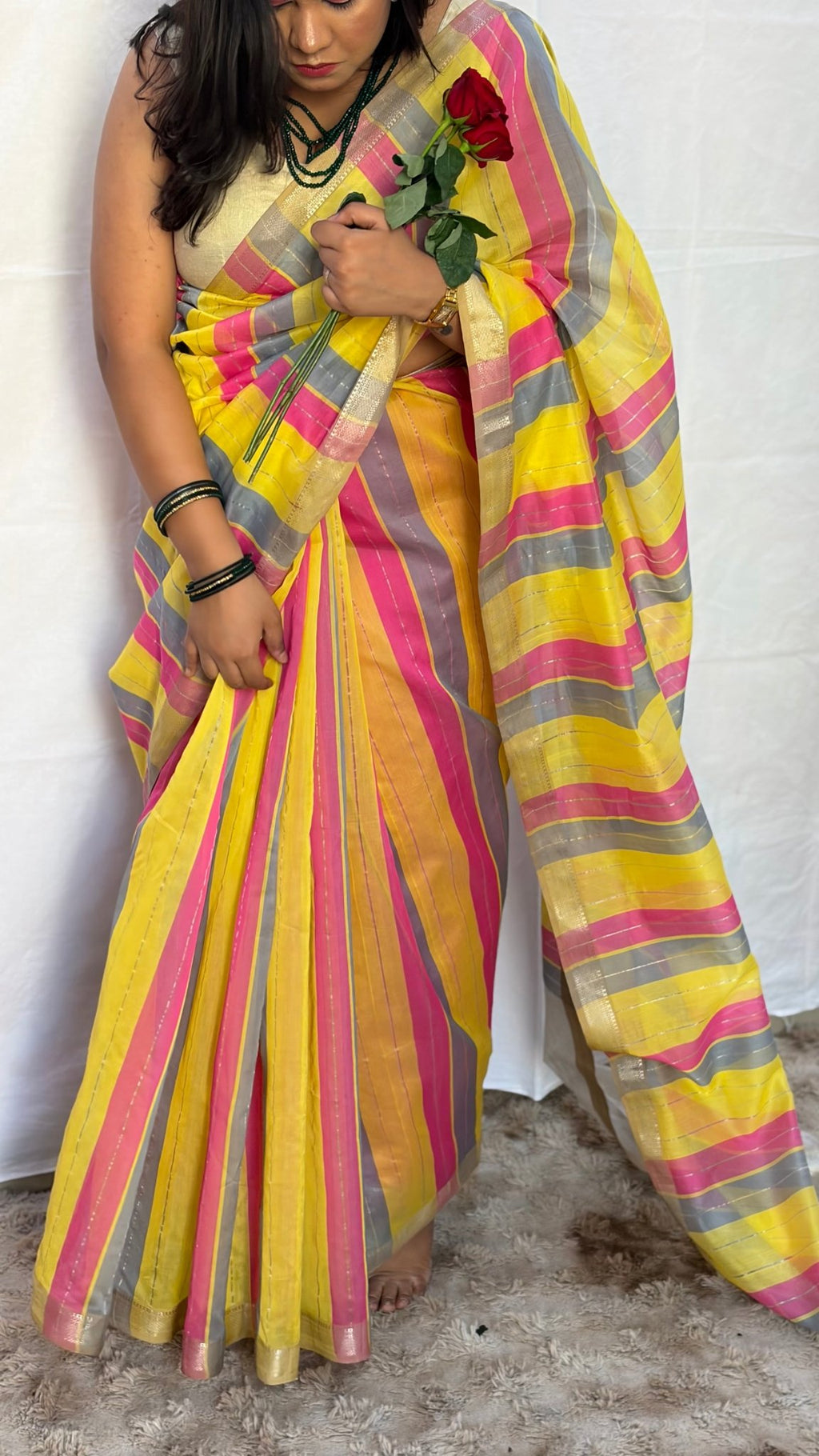 Full drape view of the hot pink, yellow, and grey striped Maheshwari handwoven saree styled for festive celebrations.