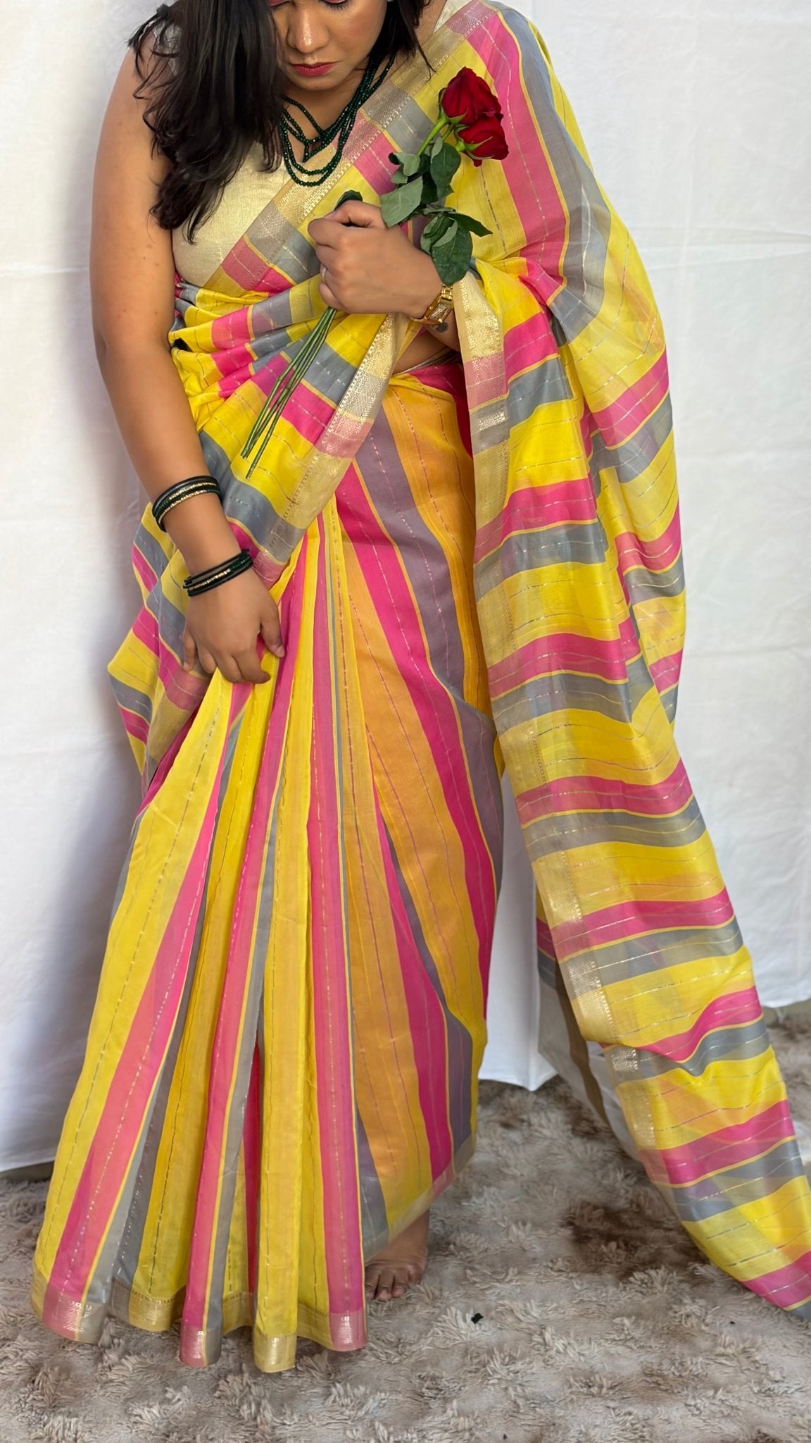 Full drape view of the hot pink, yellow, and grey striped Maheshwari handwoven saree styled for festive celebrations.