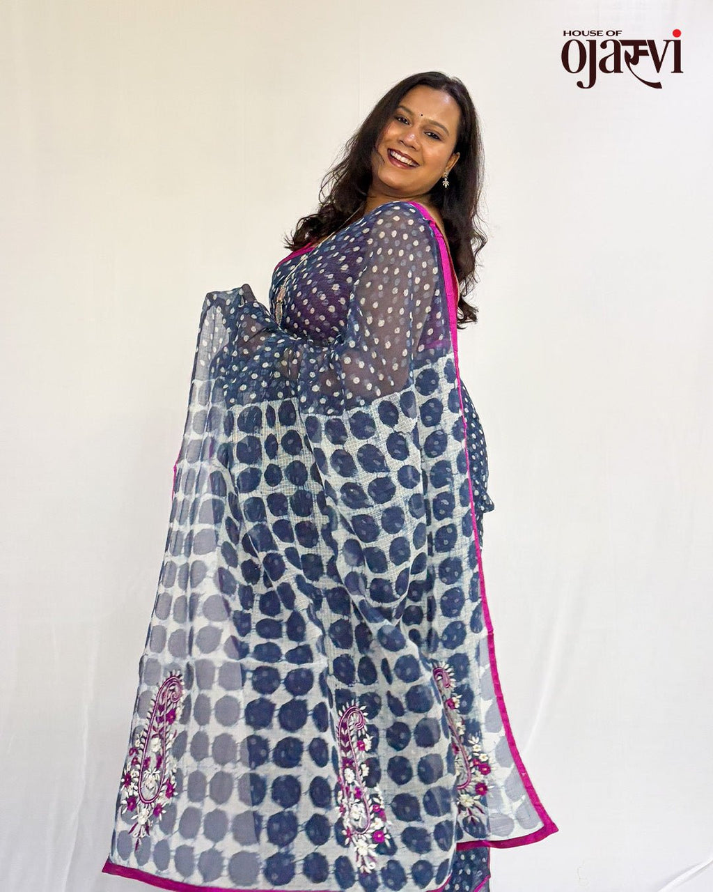 Detailed shot of the vibrant pink border and thread-embroidered paisley motifs on a handwoven Kota Doria saree.