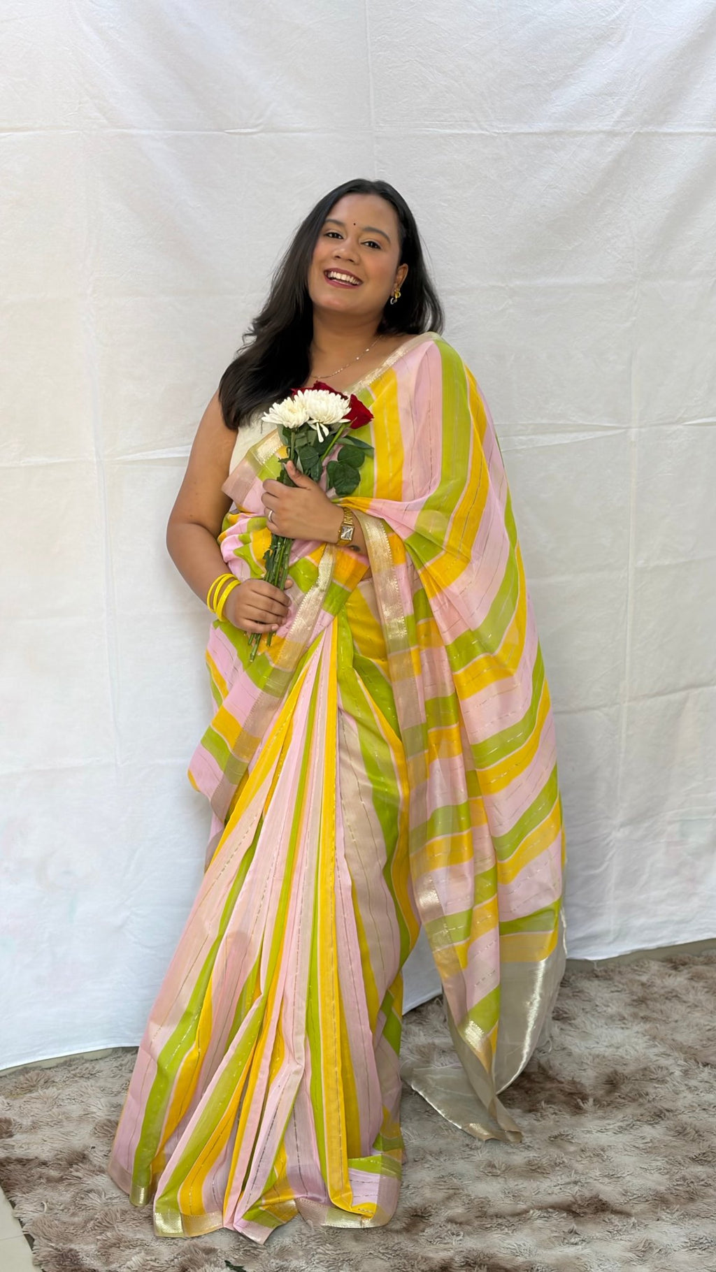 Full drape view of the pastel-toned striped Maheshwari handwoven saree showcasing traditional gold zari borders.