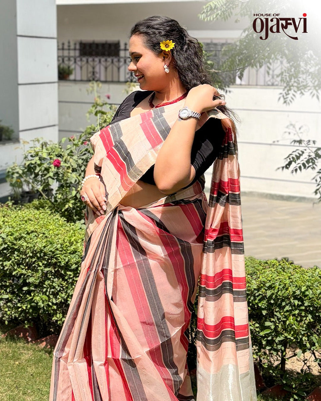 Model wearing the maroon and neutral striped handwoven Maheshwari saree outdoors by House of Ojasvi.