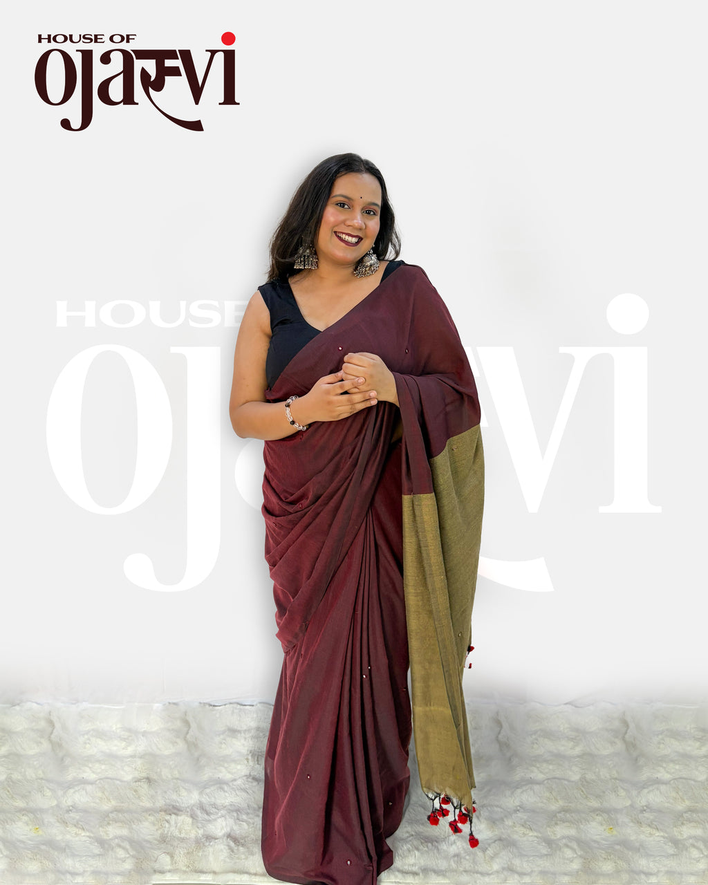 Full-length view of the maroon and olive-gold contrast pallu cotton handwoven saree highlighting the handcrafted red-and-black tassel hem