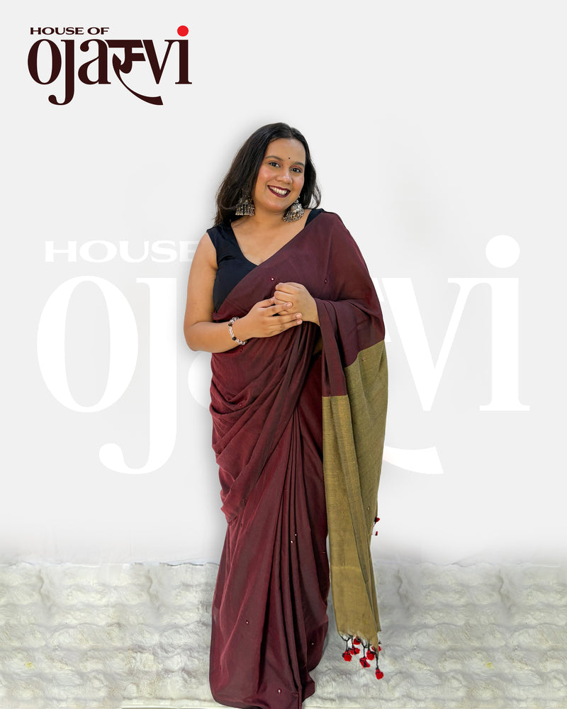 Full-length view of the maroon and olive-gold contrast pallu cotton handwoven saree highlighting the handcrafted red-and-black tassel hem