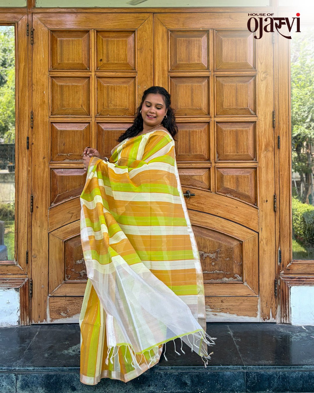 Lifestyle view showcasing the radiant drape and gold zari lines of the Maheshwari handwoven saree.