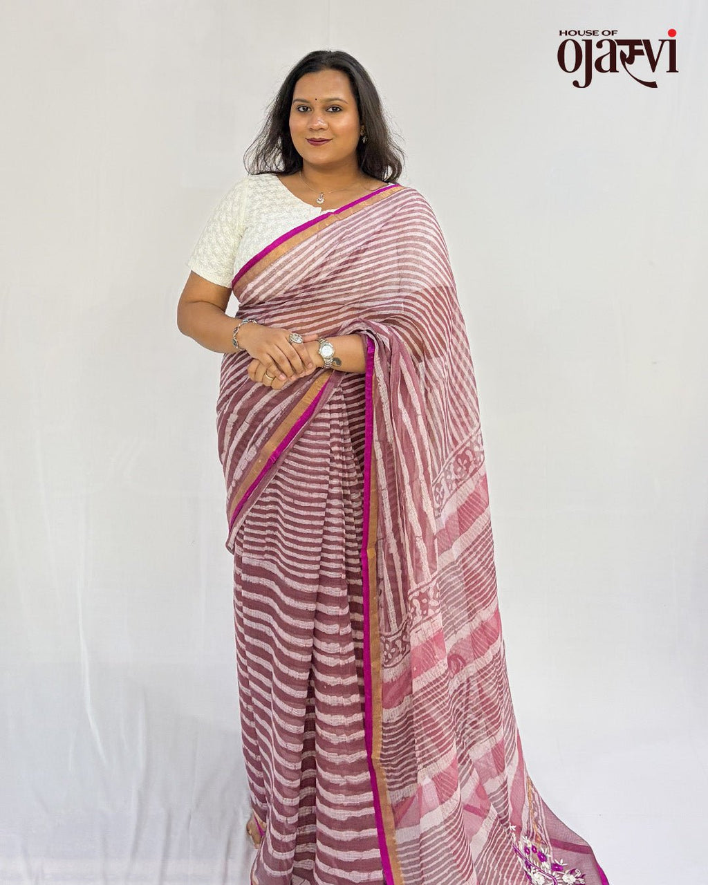 Model wearing a soft pink handwoven Kota Doria saree with a striped weave, magenta border and cream blouse by House of Ojasvi