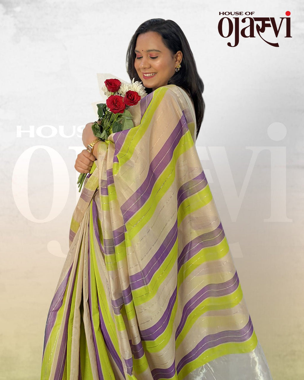 Close-up portrait of a model holding roses while wearing the purple and green striped Maheshwari handwoven saree by House of Ojasvi.