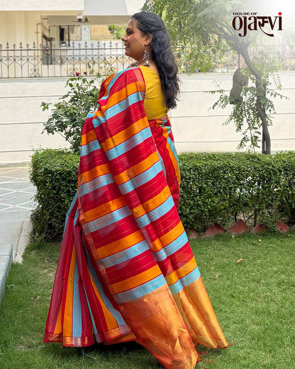 Full drape view of the red, blue, and orange striped Maheshwari handwoven saree styled for festive wear.