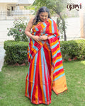 Model posing outdoors showcasing the rich gold zari border of the red, blue, and orange striped Maheshwari saree by House of Ojasvi.