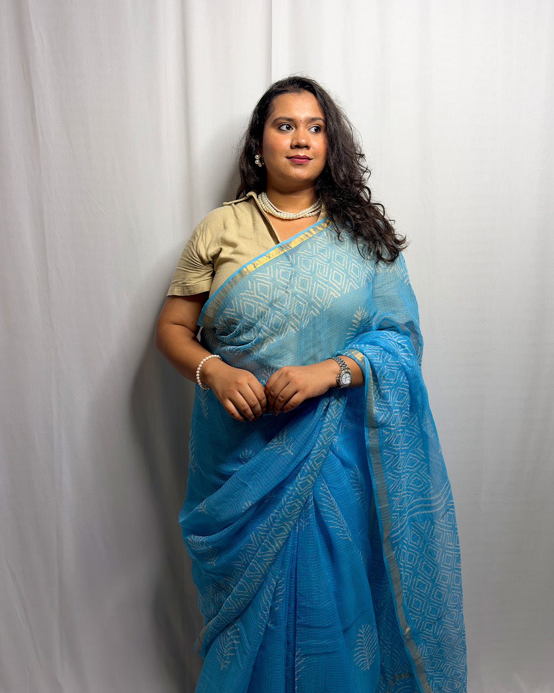 Three-quarter drape view of the sky blue and white block-print Kota Doria handwoven saree styled for modern corporate workwear