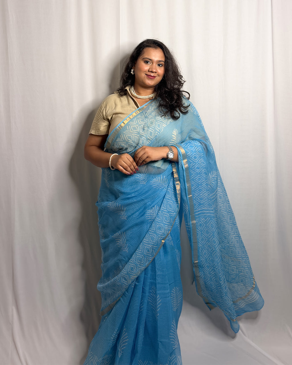 Full-length view of the sky blue block-print Kota Doria handwoven saree highlighting the botanical body motifs, geometric pallu, and fluid drape by House of Ojasvi